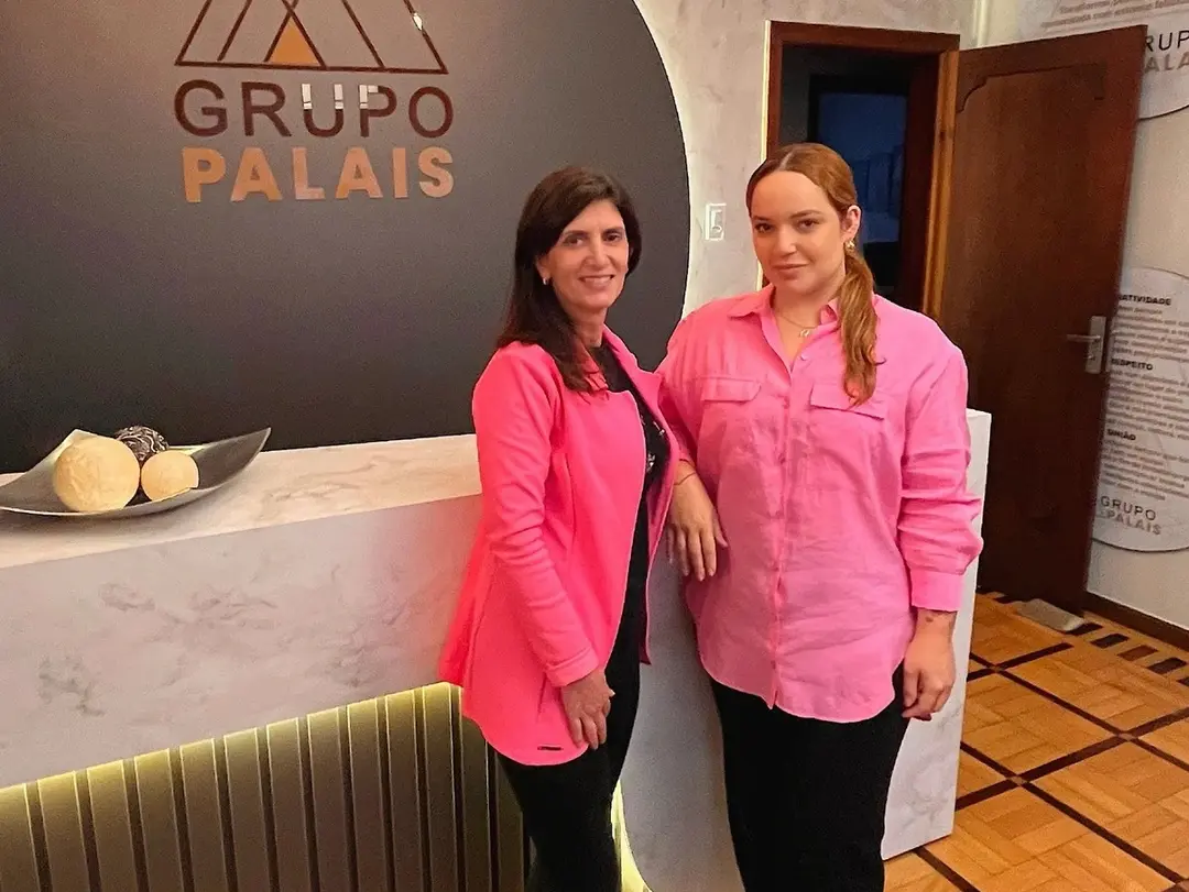 Duas mulheres de rosa na recepção do Grupo Palais